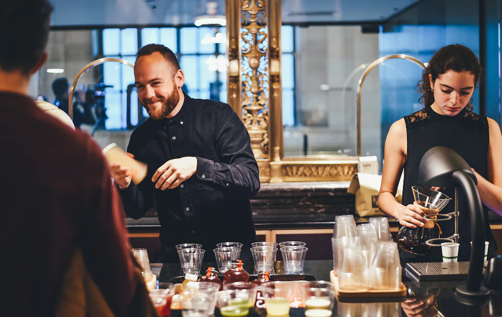 Deux barmans préparent des boissons derrière un comptoir